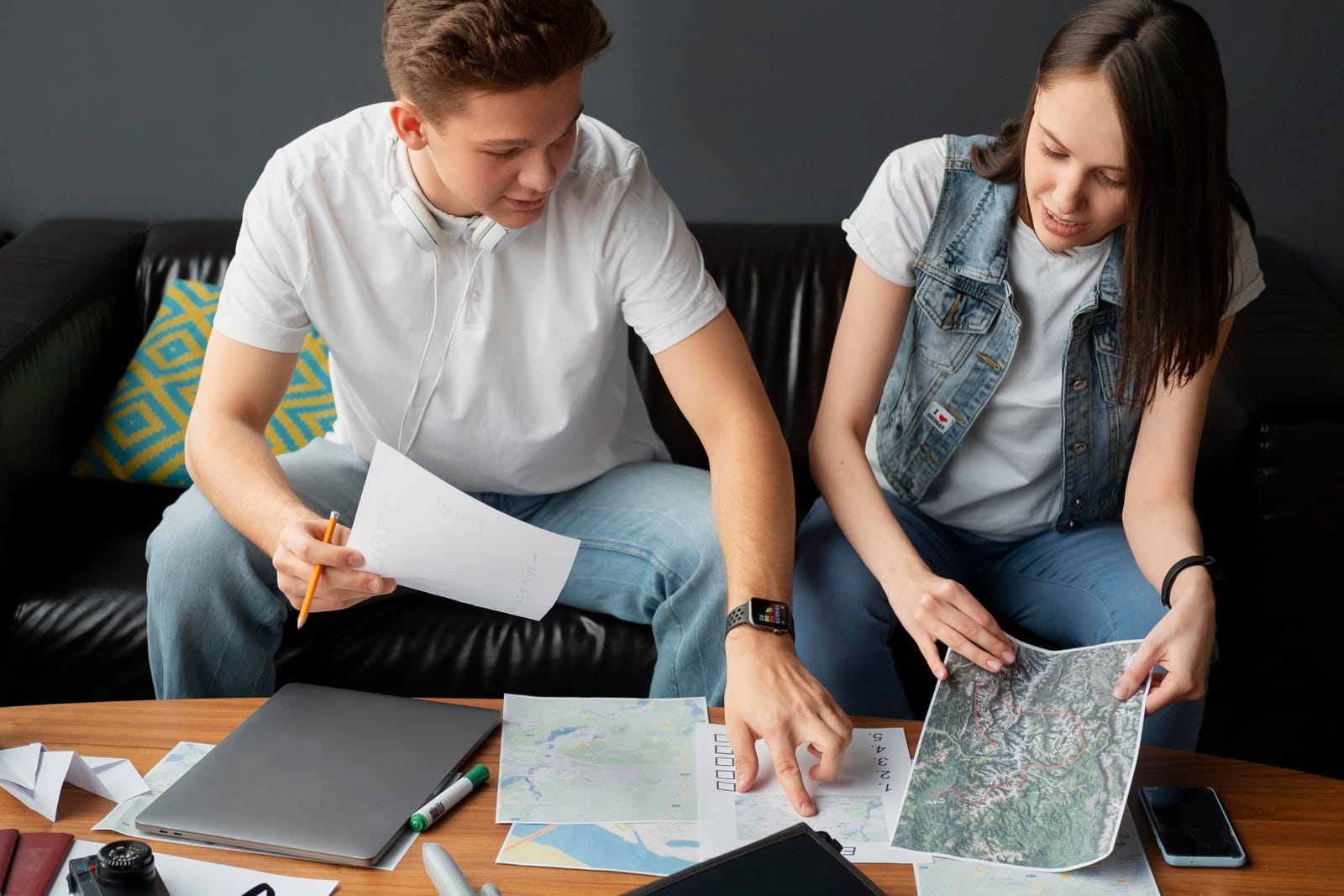 Two people reviewing maps, documents, and notes while preparing an apartment hunting checklist before renting a new home.